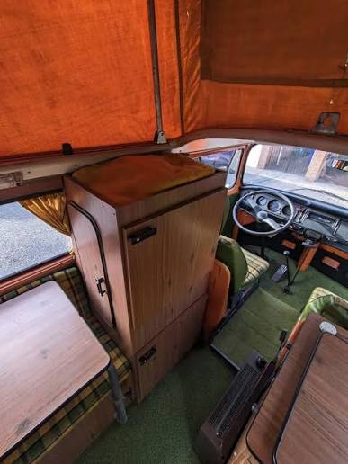 Interior original de madera con armario, mesa y tapizado escocés