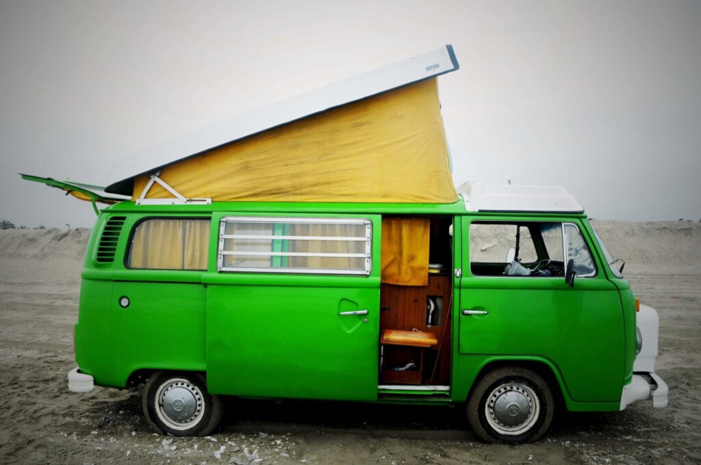 La combi en la playa con la puerta corrediza abierta mostrando la cocina