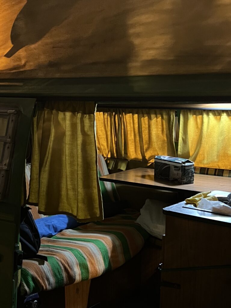 Interior con cortinas amarillas, mesa y manta de colores