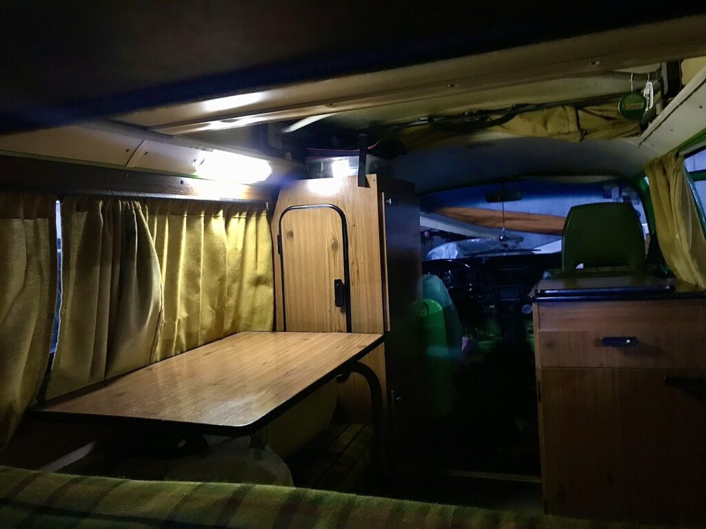 Interior de noche con la mesa, el armario y las luces encendidas