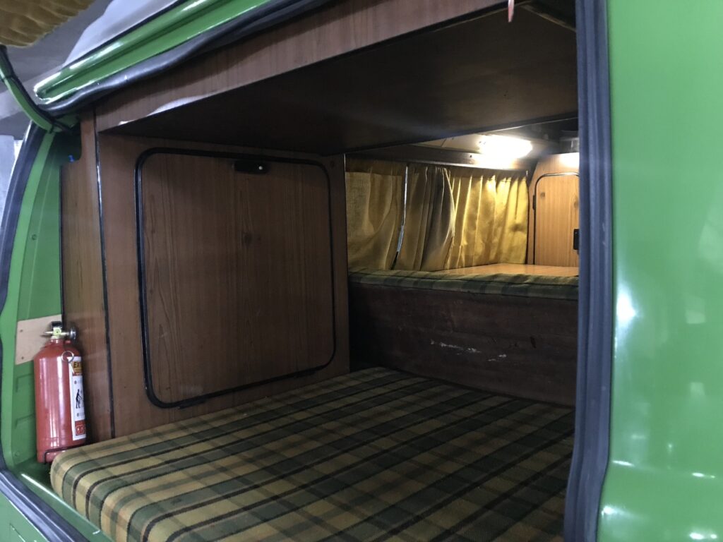Asiento cama con tapizado escocés visto desde la puerta corrediza