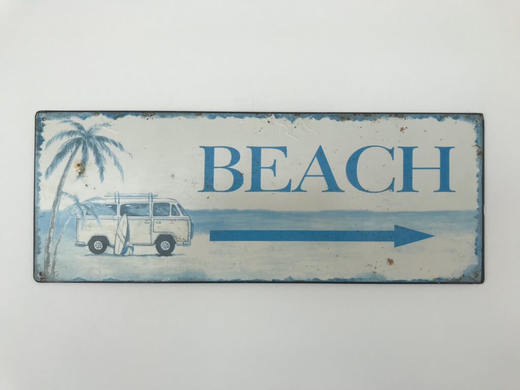Cartel de chapa con la palabra BEACH y una combi
